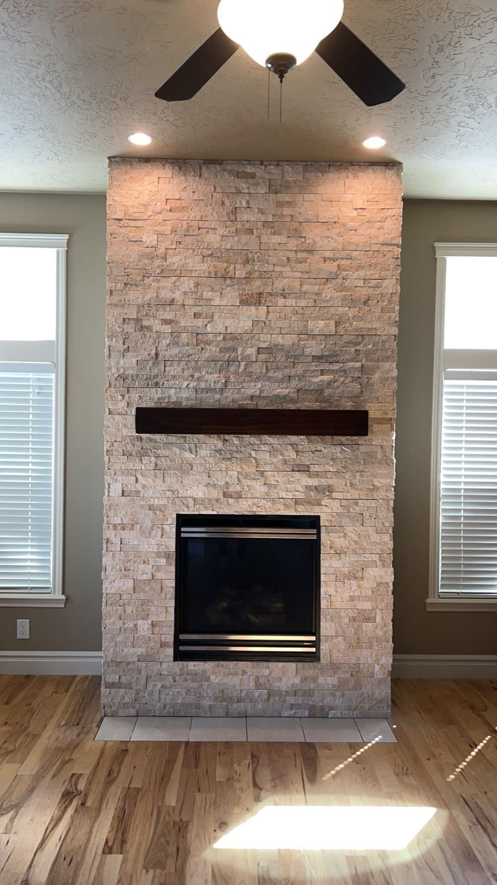 Brick-look tile fireplace with a wood mantel