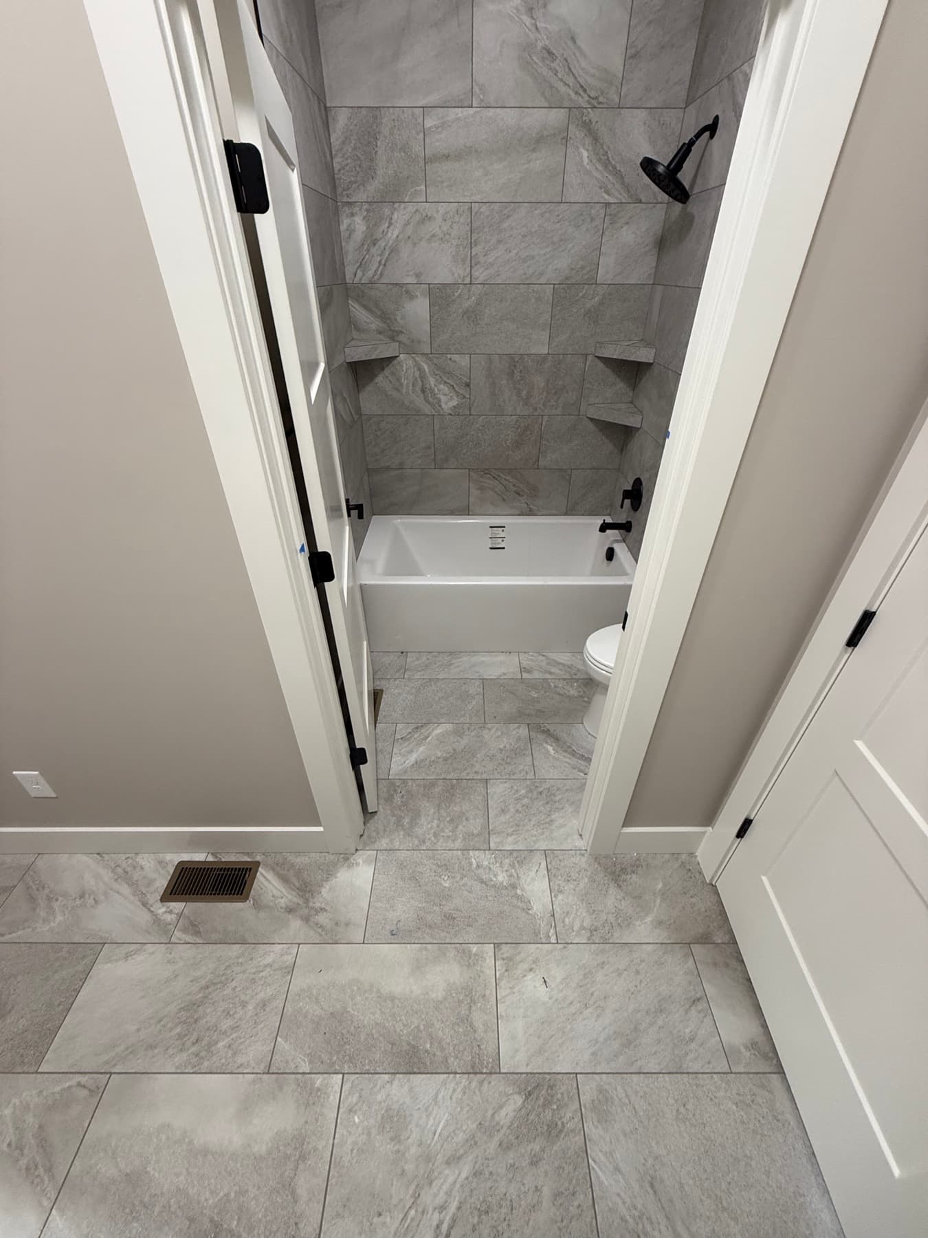 Freestanding soaking tub with marble tile surround