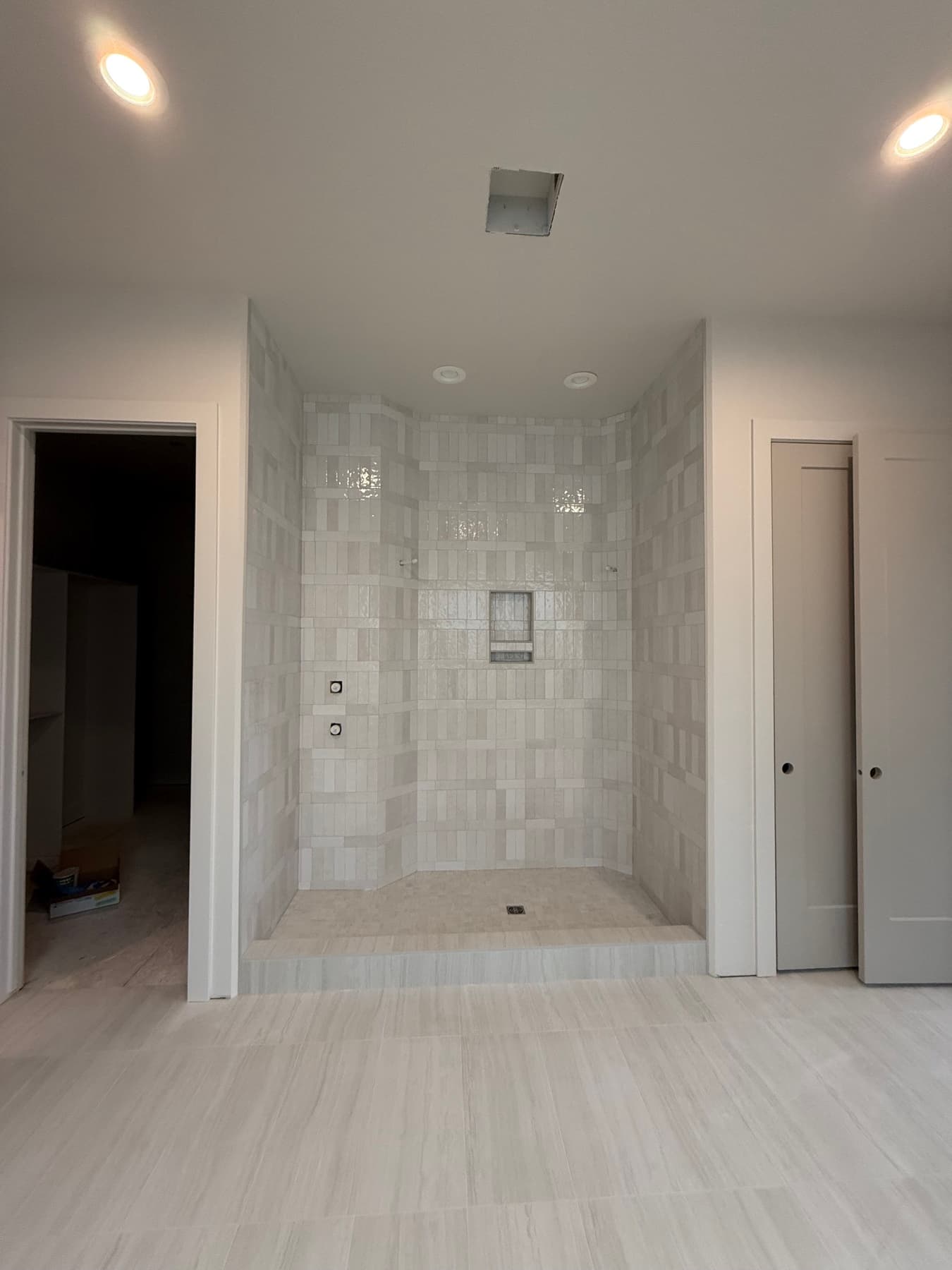 Marble tile shower with built-in bench and niche