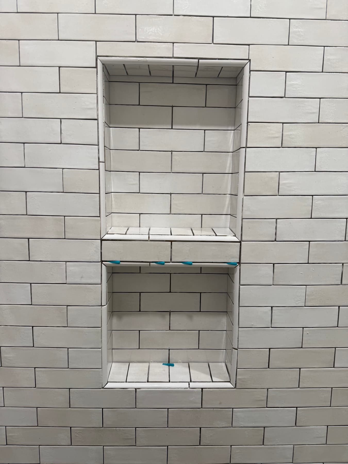 White stacked tile shower with niches